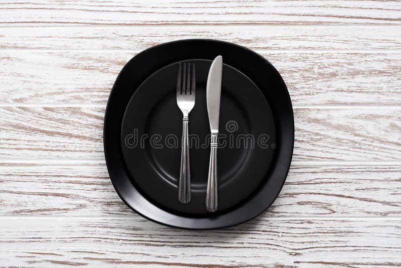 Empty plate fork knife silverware white wooden table background royalty free stock images