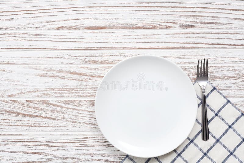 Empty plate napkin fork silverware white wooden table background royalty free stock photography
