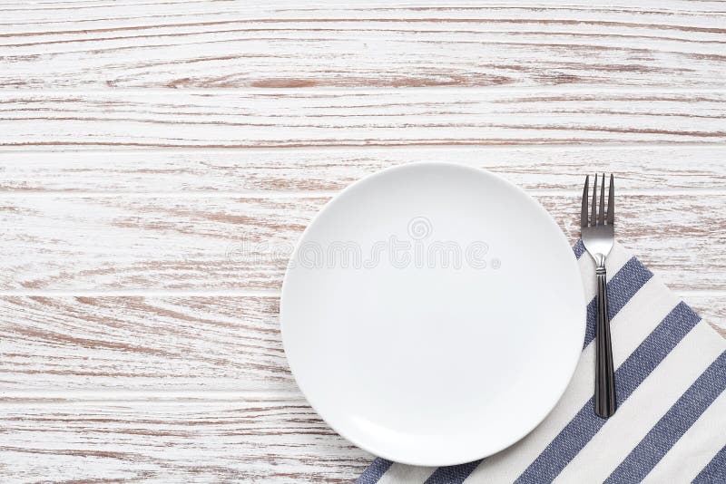 Empty plate napkin fork silverware white wooden table background stock image