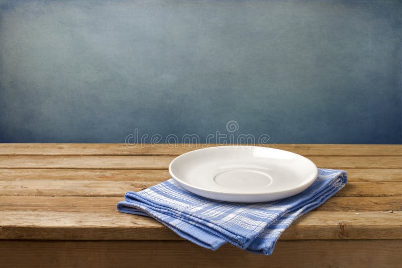 Prázdny tanier na obrus na drevené tabuľky, cez grunge modrom pozadí.