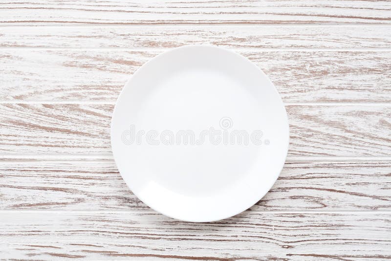 Empty plate on white wooden table background flat lay