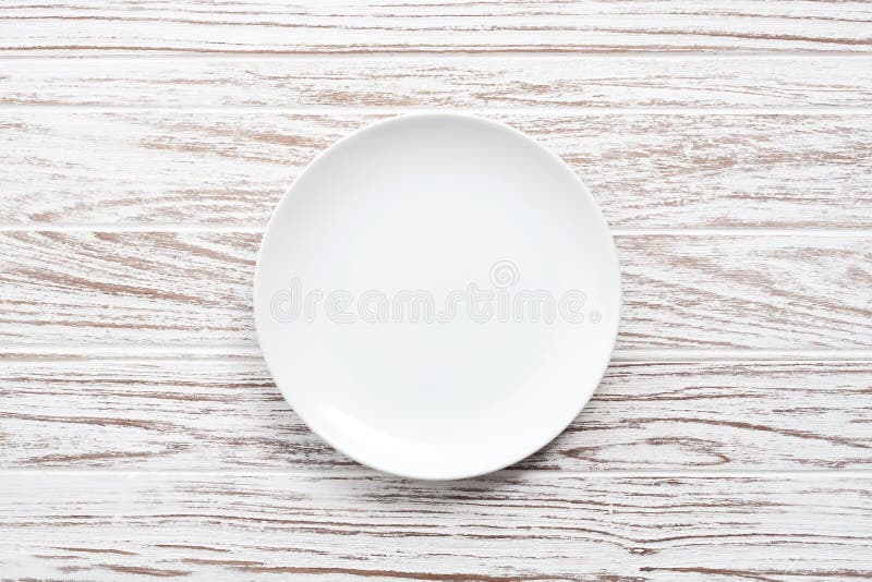 Empty plate on white wooden table background flat lay royalty free stock photography