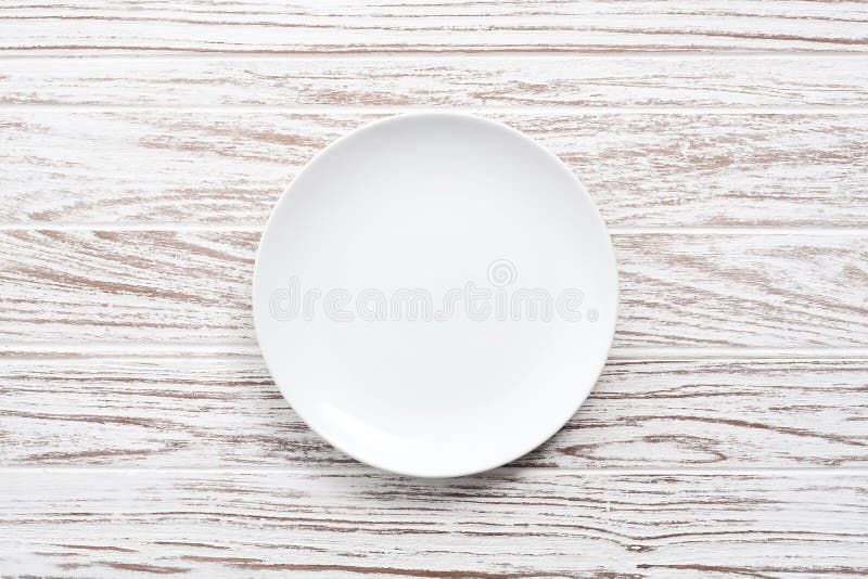 Empty plate on white wooden table background flat lay