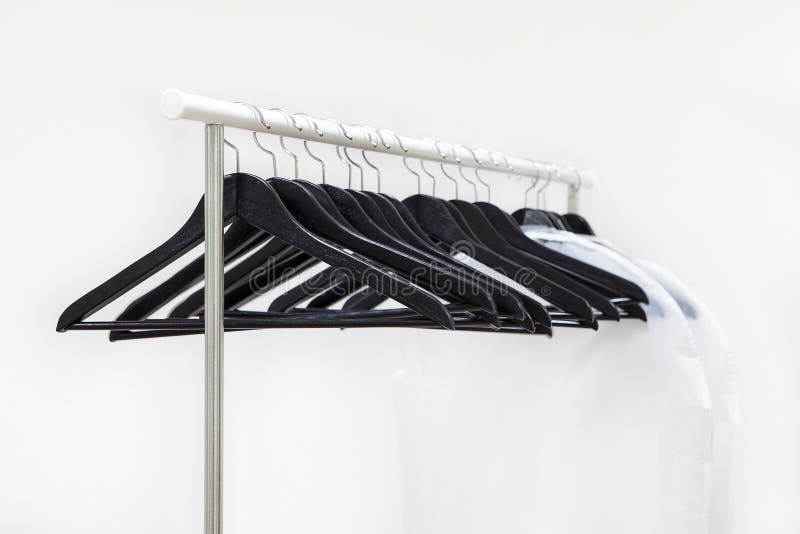 Empty Rack with Hanging Black Hangers and Bags for Clothes Stock Image