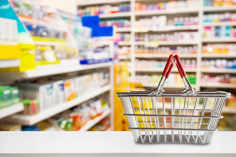 Empty shopping basket on pharmacy drugstore counter with blur shelves background