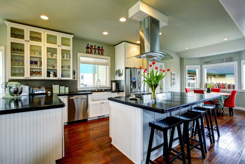 Empty simple old kitchen with hardwood floor and white cabinets