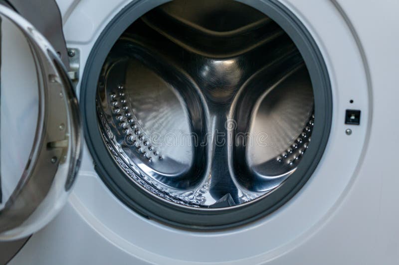 Close up view of an open front loading washing machine with empty stainless steel drum. Detailed metallic texture and circular symmetry emphasize modern household technology. Concept of cleaning, hygiene, and everyday domestic routine. Metal steel drum stock images, royalty-free photos and pictures