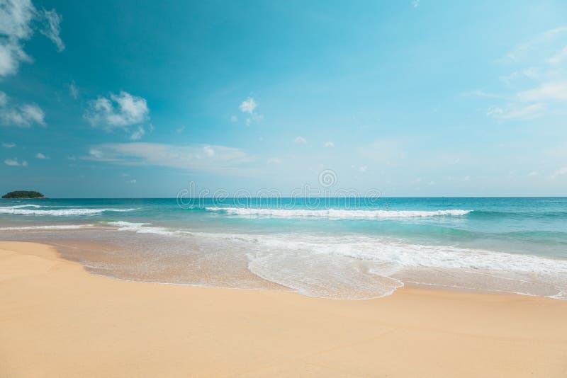 Empty summer beach, on a sunny day with blue sky, and white clouds Sea sand beach, with the soft wave moving to the shore, and