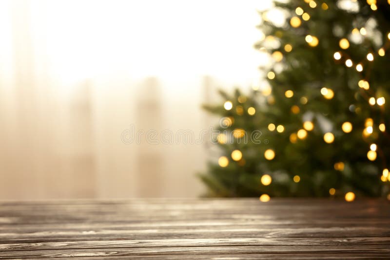 Empty table and blurred fir tree with yellow Christmas lights on background, bokeh effect royalty free stock photo