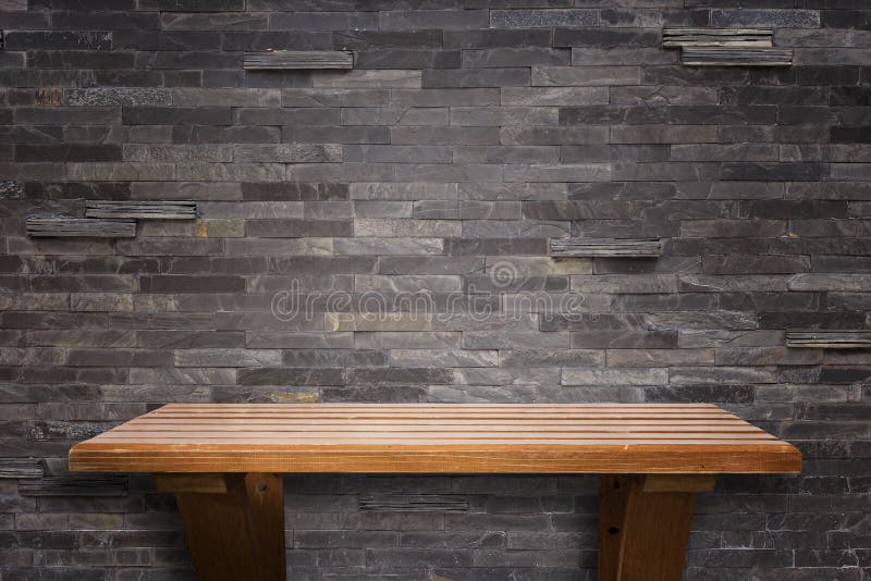 Empty top wooden shelves and stone wall background