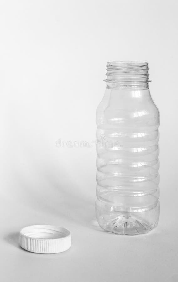 Empty Transparent Open Plastic Bottle without Cap, Cap Lies Next To a