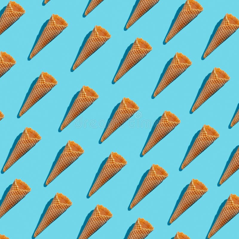 Empty wafer ice cream cones continuous pattern on blue background. Isoclate top view, hard light stock photos