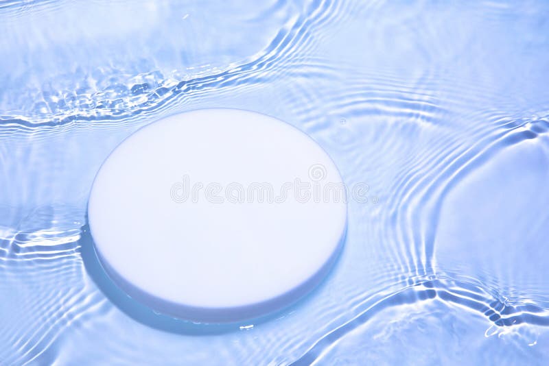 Empty white circle podium on transparent blue water background with copy space