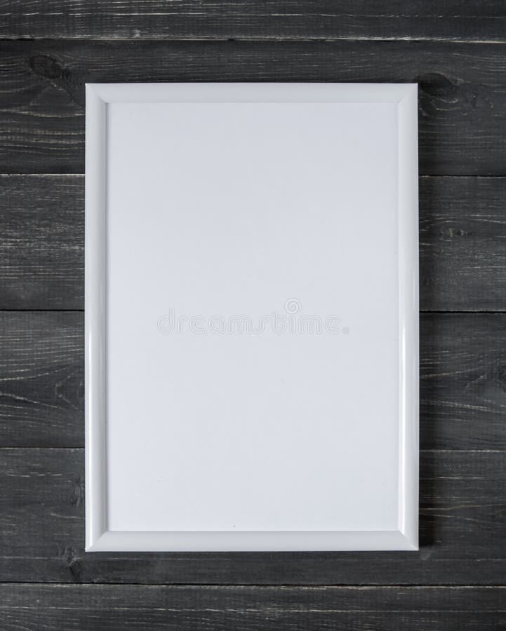 Empty white frame for a picture on a dark wooden background royalty free stock photography Empty white frame for a picture on a dark wooden background royalty free stock photography