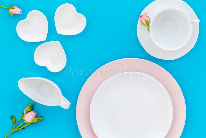 Prázdny biely a ružový farbistý doska a ruže prestieranie na modrý jedálenský stôl kopírovať priestor.