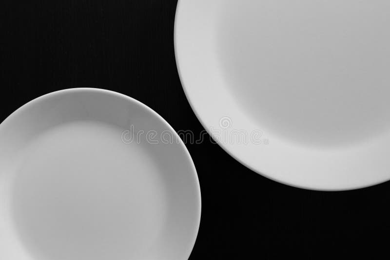 Empty white plates on black wooden table stock image Empty white plates on black wooden table stock image