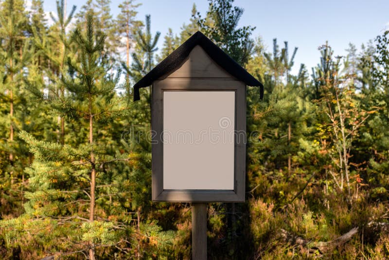 Empty white sign in nature, with green trees in the background royalty free stock photos