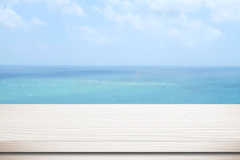 Empty white wood table over blur sea and blue sky background royalty free stock photography