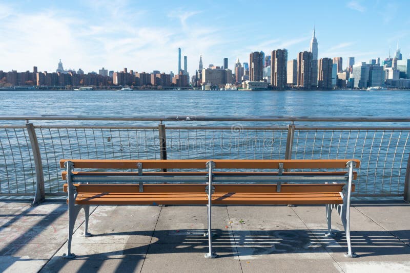 Empty Bench at a Park in Greenpoint Brooklyn New York looking out towards the East River and the Manhattan Skyline