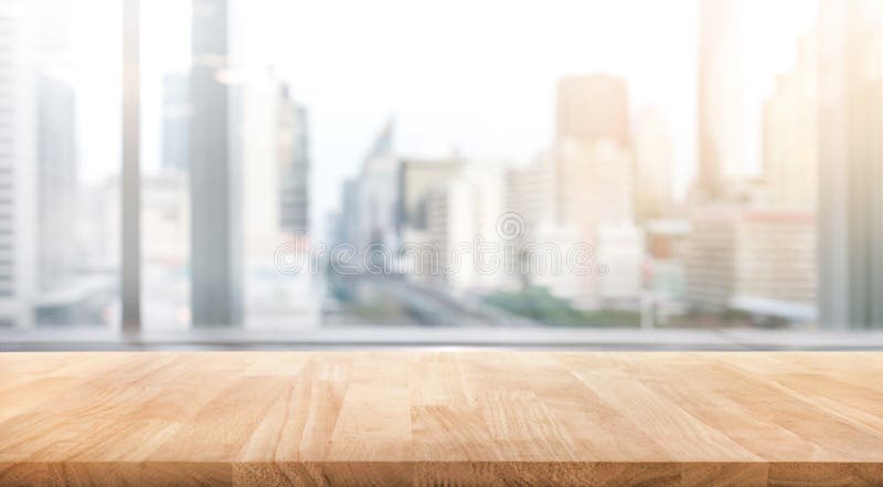 Empty wood table with blur room office and window city view