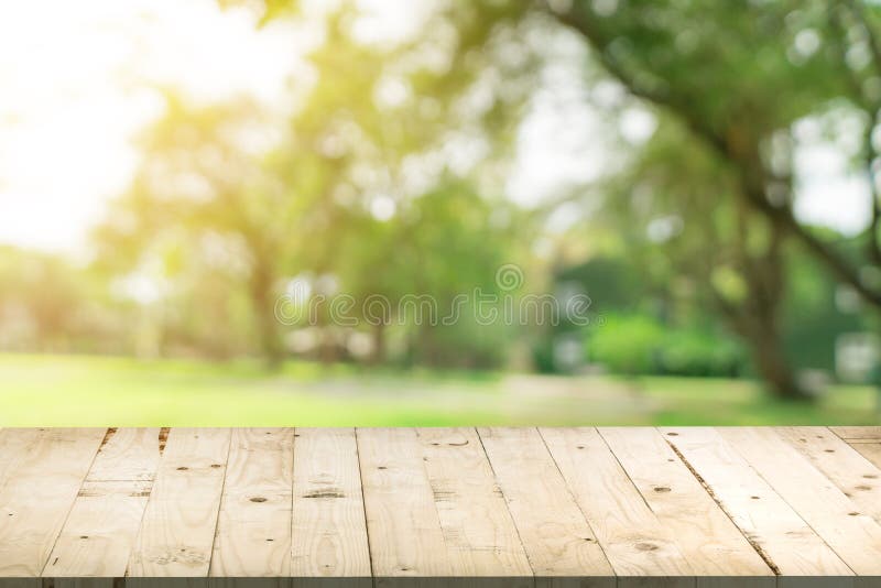 Empty wood table and defocused bokeh and blur background of garden trees in sunlight, display montage for product. stock photos Empty wood table and defocused bokeh and blur background of garden trees in sunlight, display montage for product. stock photos