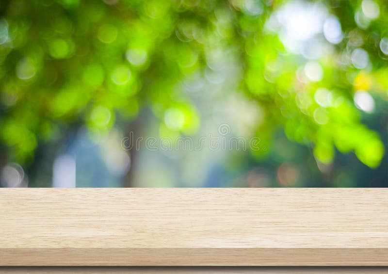 Empty wood table over blurred trees with bokeh background royalty free stock photo