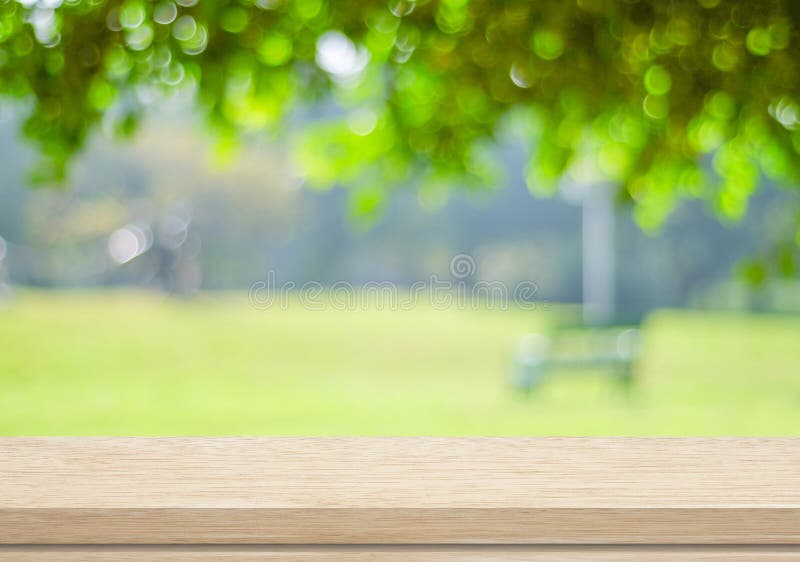 Empty wood table over blurred trees with bokeh background royalty free stock photography