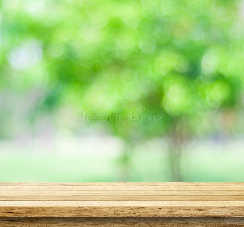 Empty wood table over blurred trees with bokeh background royalty free stock photography