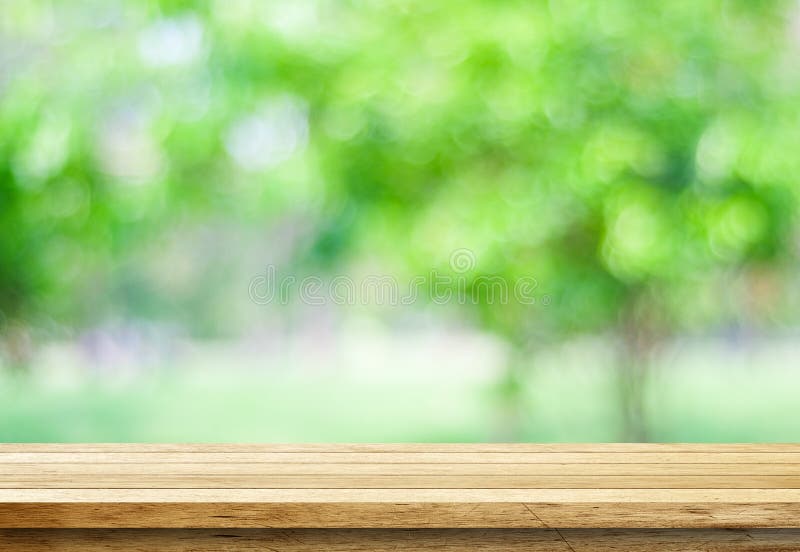 Empty wood table over blurred trees with bokeh background royalty free stock image