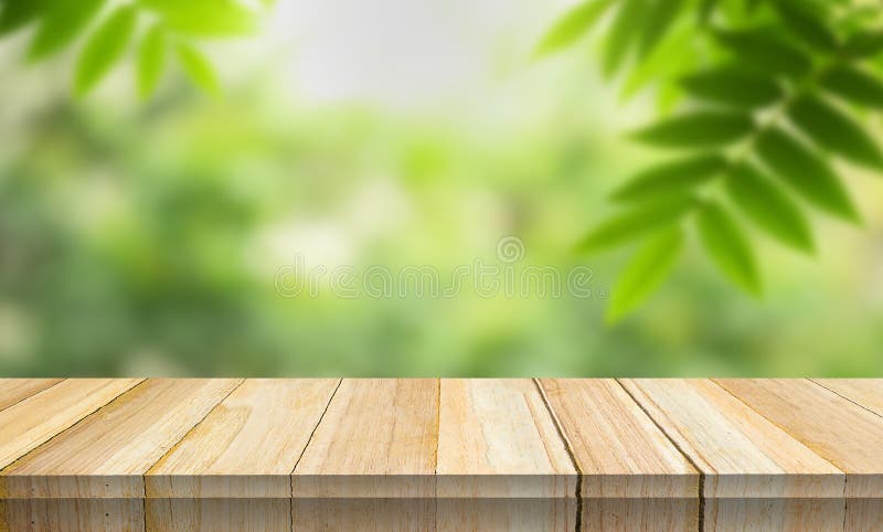 Empty wood table top with blur background of nature lush green forest. royalty free stock images