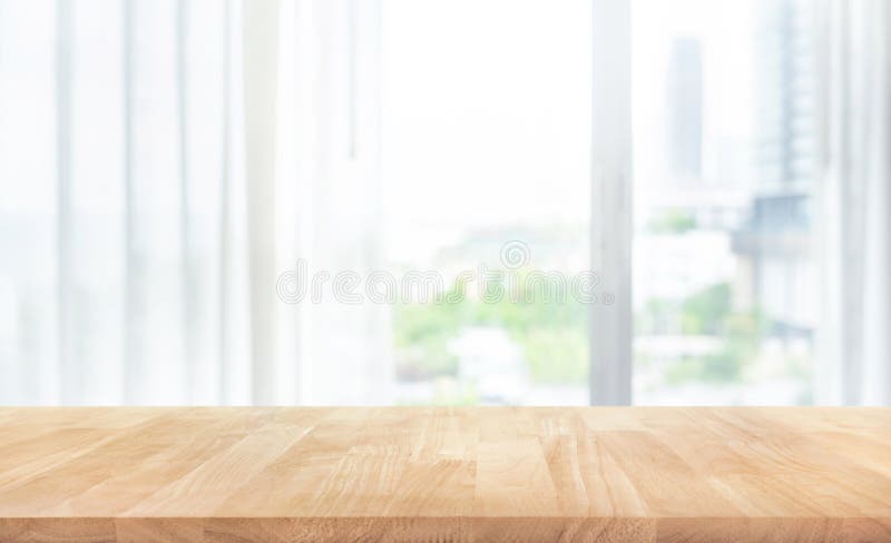 Empty of wood table top on blur of white curtain with window view background