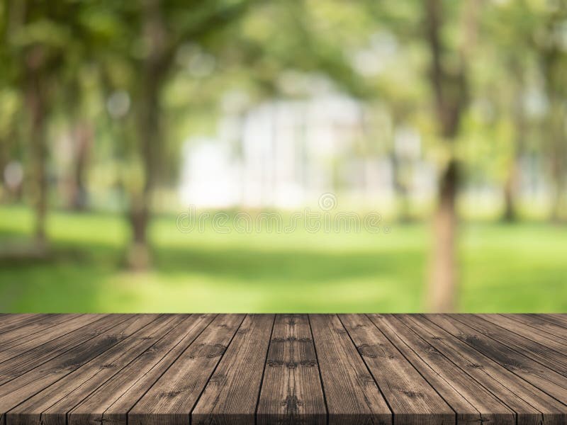 Empty wood table top on nature green blurred background at garden,space for montage show product