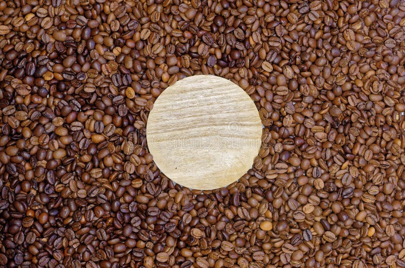 Empty wooden round board in roasted coffee beans. Round wooden board lies n the roasted coffee beans as background royalty free stock photography Empty wooden round board in roasted coffee beans. Round wooden board lies n the roasted coffee beans as background royalty free stock photography