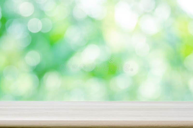 Empty wooden table top with blurred green natural abstract background. stock photo