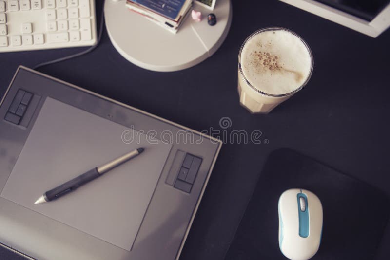 Empty workspace of a designer with graphic tablet and pen, keyboard and mouse on a black table. Minimalistic modern style royalty free stock photography