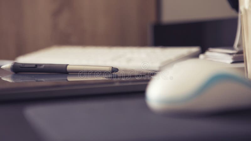 Empty workspace of a designer with graphic tablet and pen, keyboard and mouse on a black table. Minimalistic modern style royalty free stock photography
