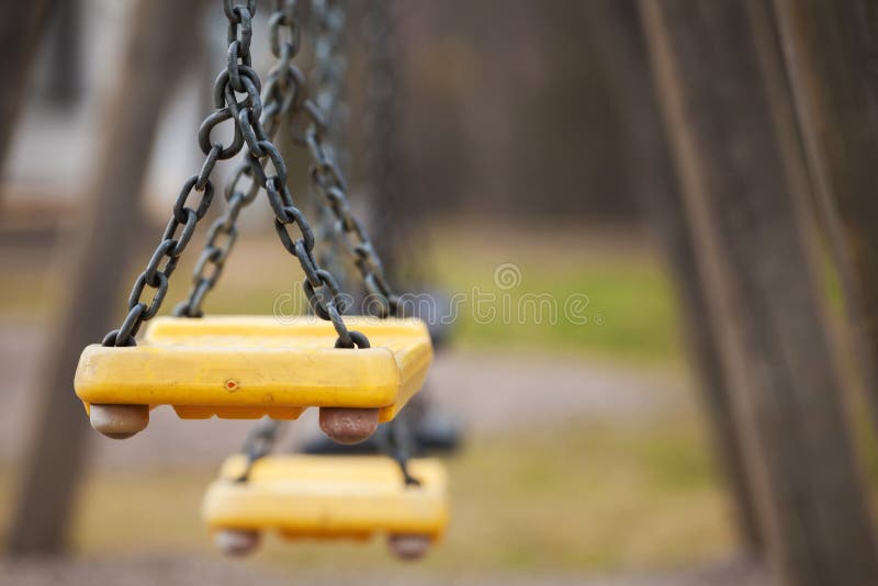 Empty yellow plastic swings royalty free stock photography
