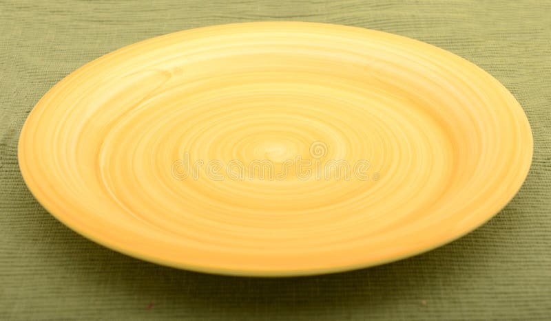 Empty yellow plate on green background royalty free stock photography
