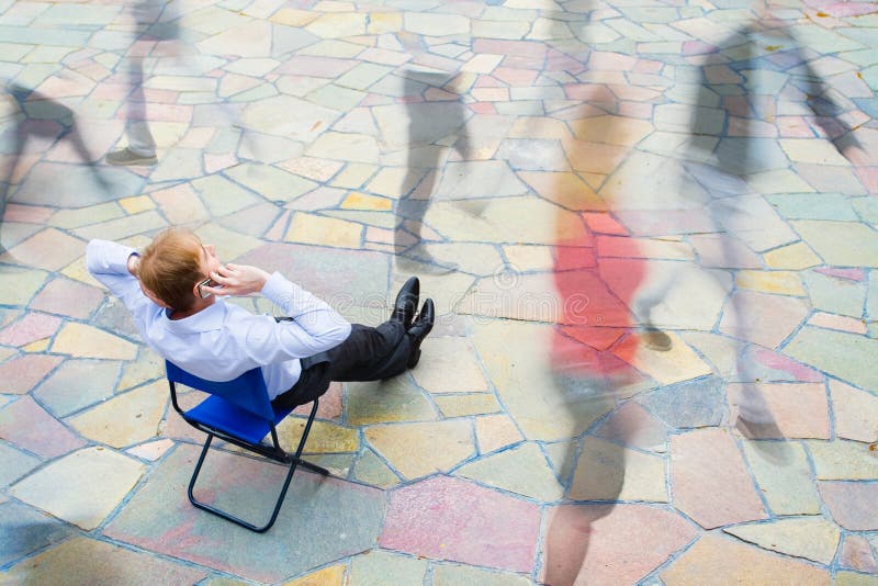En affärsman som sitter och kallar gatan arkivfoto En affärsman som sitter och kallar gatan arkivfoto