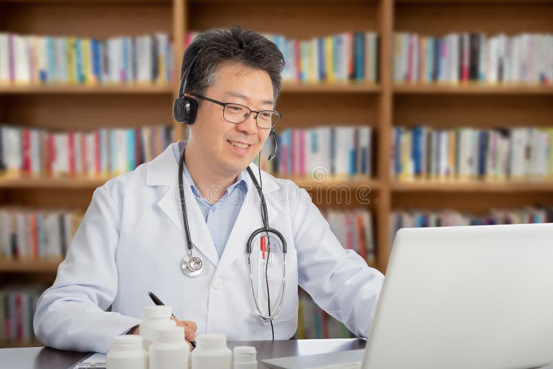 En asiatisk doktor som konsulterar avlägset med en patient Telehealth begrepp arkivfoto En asiatisk doktor som konsulterar avlägset med en patient Telehealth begrepp arkivfoto