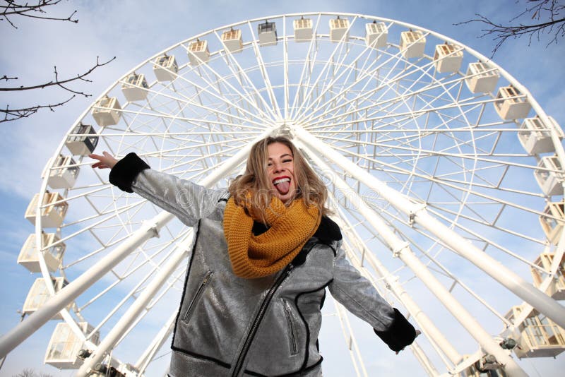 En attraktiv blond flicka som söker efter ett äventyr på en ferris-rund attraktion Glad positiv stämning arkivfoto En attraktiv blond flicka som söker efter ett äventyr på en ferris-rund attraktion Glad positiv stämning arkivfoto