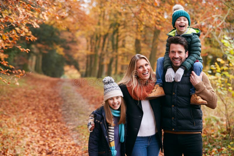En bild av familjen som går längs höstskogar med far som bär på skuldra royaltyfri fotografi