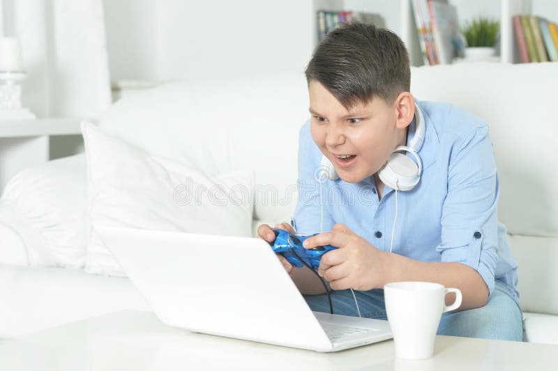 En bild av pojkens spel med en bärbar dator arkivfoton