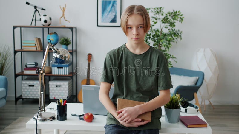 En bild av smarta tonåringar som står i hemmet och tittar på kameran med seriöst ansikte arkivfilmer