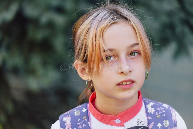 En bild av en 9-10-årig flicka på neutral bakgrund. Stängande av en skolflickas porträtt arkivfoto
