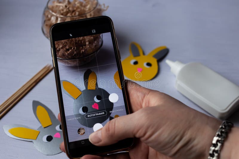 En bloggare tar bilder av processen med att göra påskavlor på sin telefon stock illustrationer