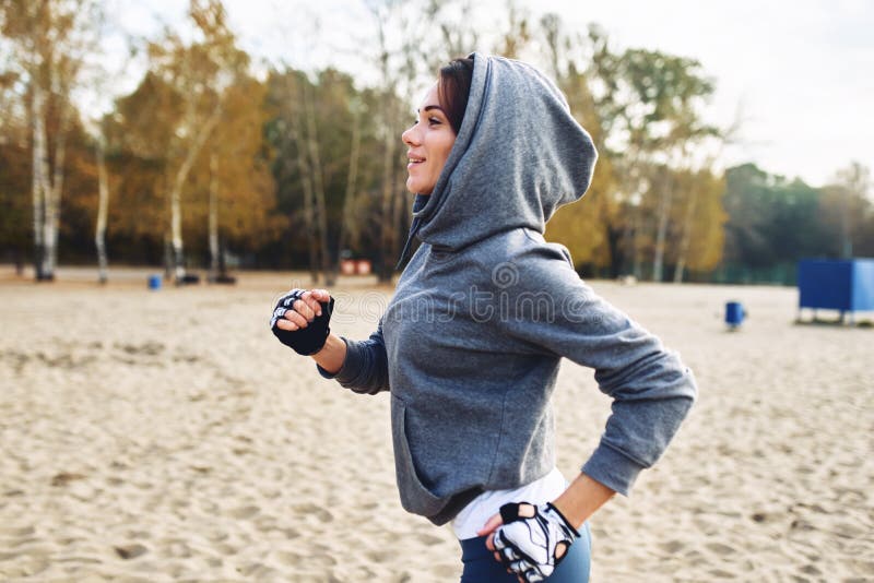 En brunett i en baddräkt på gatan på stranden Sport på gatan royaltyfri foto