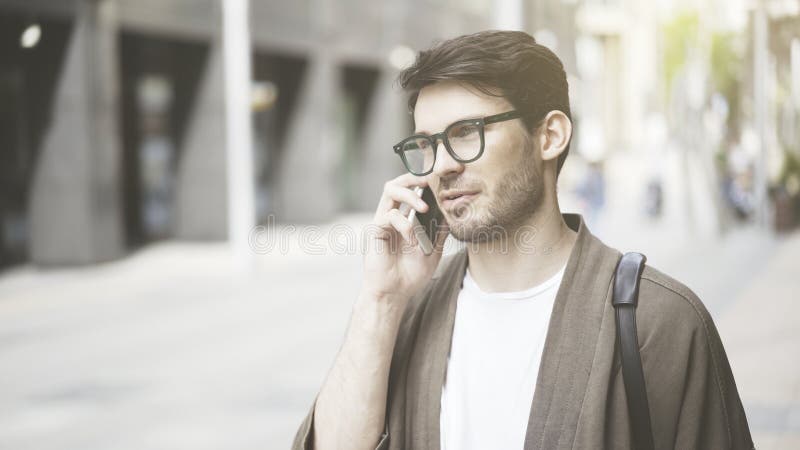 En closeup av den allvarliga unga mannen som har en appell på gatan royaltyfria bilder En closeup av den allvarliga unga mannen som har en appell på gatan royaltyfria bilder