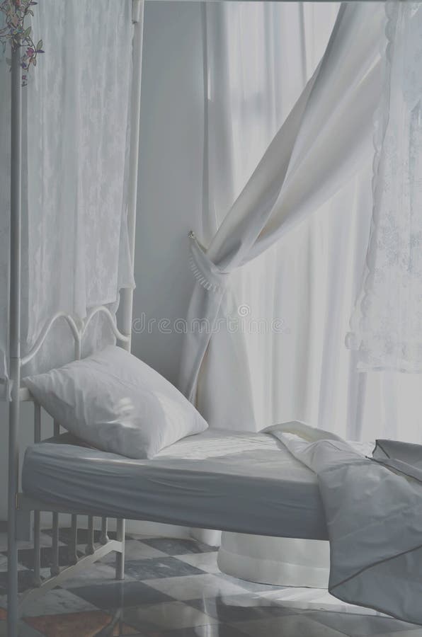 En el dormitorio hay una cama blanca fotografía de archivo libre de regalías En el dormitorio hay una cama blanca fotografía de archivo libre de regalías