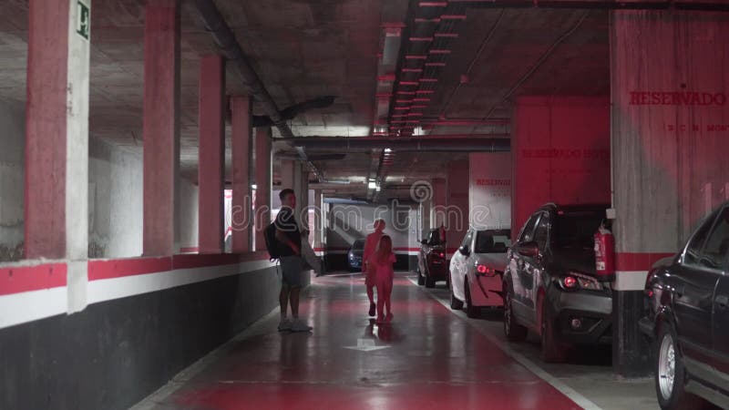 En far och barn åker till bilen på parkeringsplatsen under marken lager videofilmer